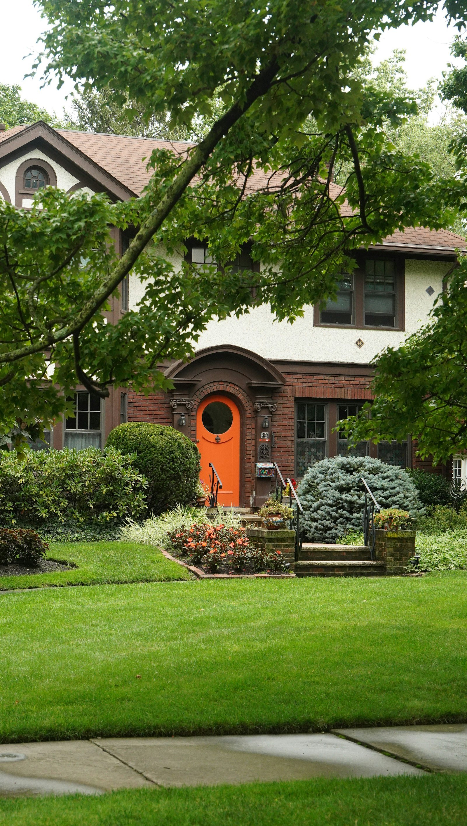 A Madison Heights home with a freshly mowed lawn and planted beds in summer.